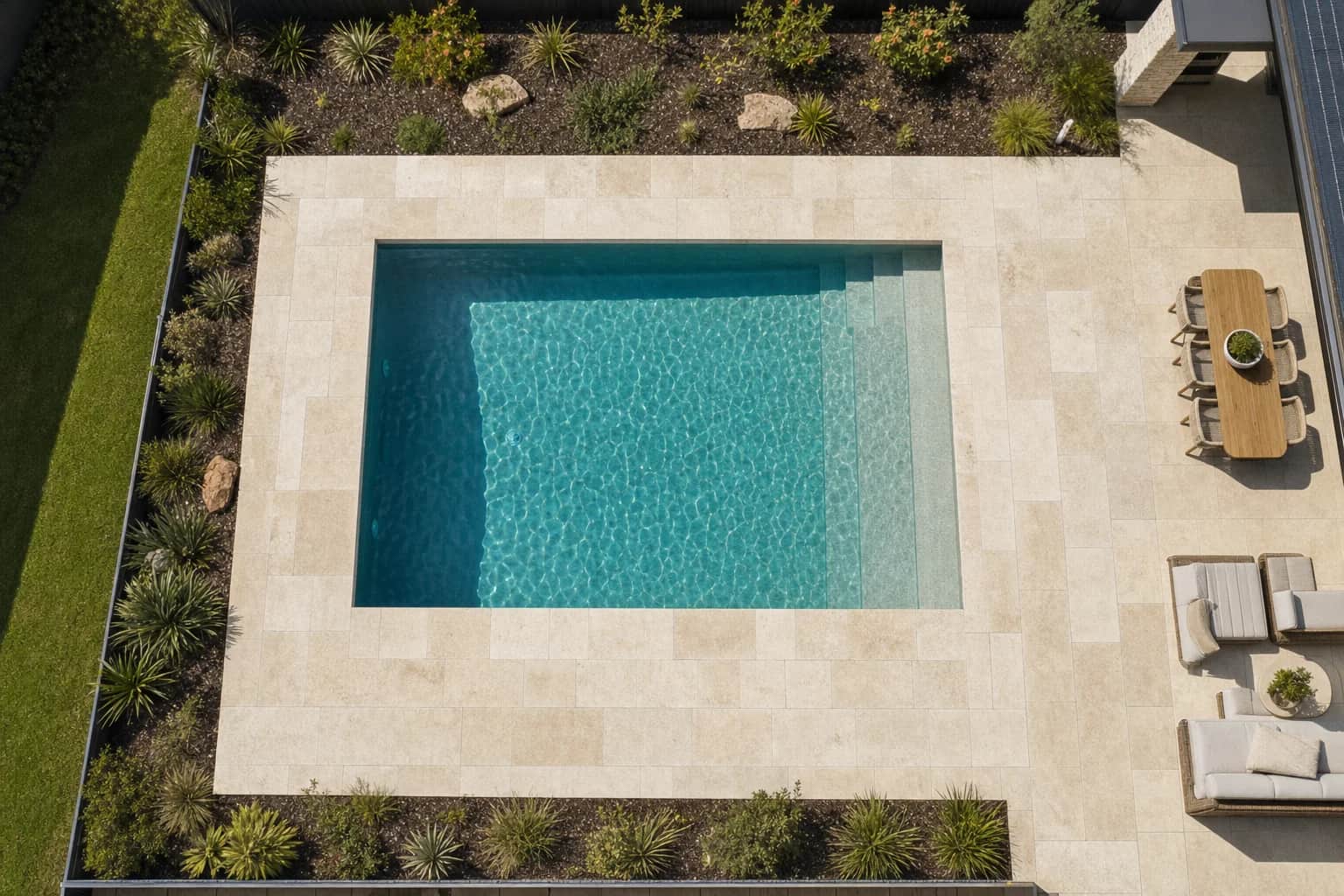 Overhead view of a rectangular pool and its full travertine surround at a Perth home