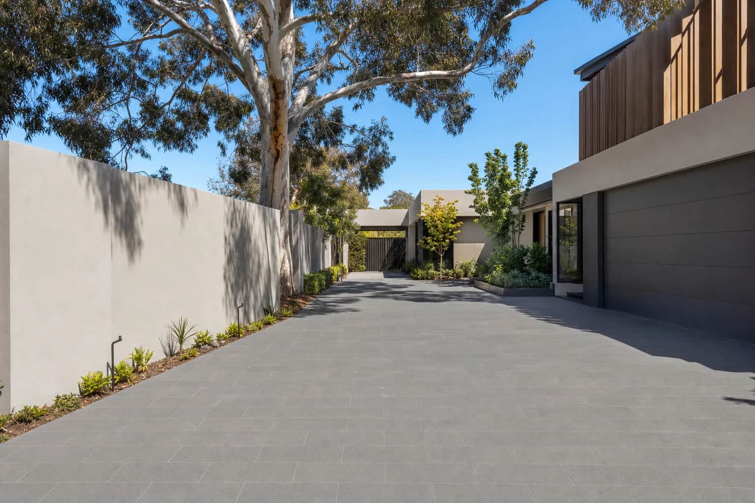 Charcoal large-format porcelain driveway paving laid in a tight stack bond